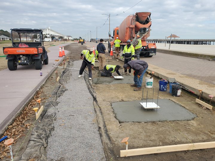 Crew placing concrete in a prepared waterfront foundation