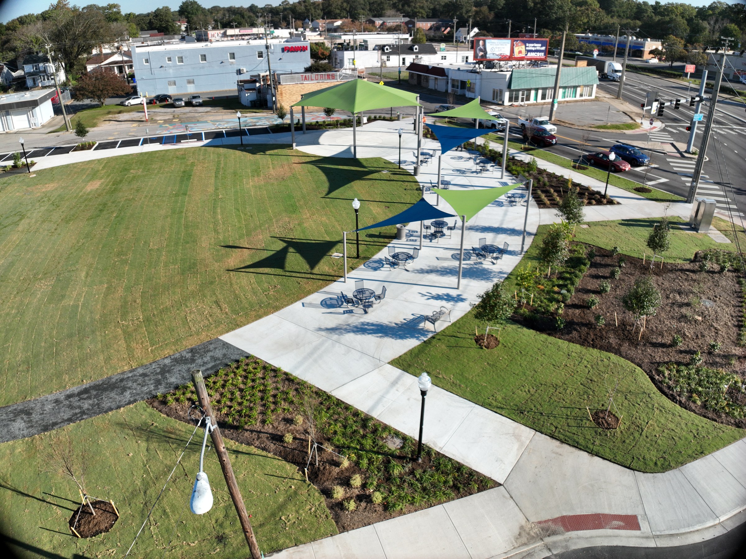 Curved paths connect the lawn with shade structures and seating.